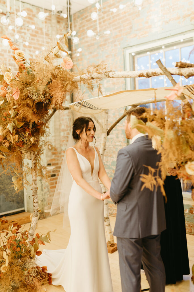 indoor wedding ceremony with autumnal floral arrangements